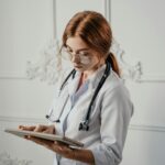 Profesional de la salud usando una tableta con gráficos de datos de Inteligencia Artificial para análisis médico. La escena r