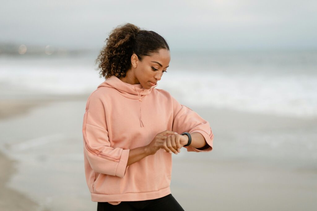 Mujer sonriente y activa, de unos 30 años, observando gráficos detallados de datos de salud en su smartwatch al aire libre, r