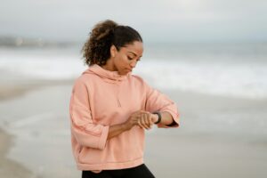 Mujer sonriente y activa, de unos 30 años, observando gráficos detallados de datos de salud en su smartwatch al aire libre, r