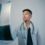 Un médico examinando imágenes médicas digitales asistido por una interfaz de inteligencia artificial, mostrando gráficos y da