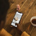 Persona mayor sonriendo mientras habla con un médico a través de una tablet en su sala de estar, representando el acceso a la