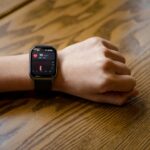 Persona usando un smartwatch con IA, visualizando datos de salud y bienestar. Representa el monitoreo activo y la prevención