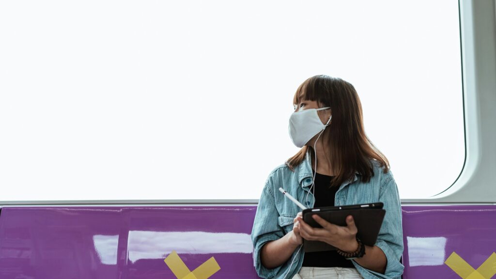 Una mujer joven sonriente, de perfil, interactúa con una aplicación de salud en su tablet, mostrando gráficos y datos de bien