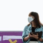 Una mujer joven sonriente, de perfil, interactúa con una aplicación de salud en su tablet, mostrando gráficos y datos de bien