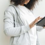 Mujer serena usando una tablet. La pantalla muestra una interfaz de aplicación de IA en salud mental, reflejando apoyo digita