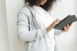 Mujer serena usando una tablet. La pantalla muestra una interfaz de aplicación de IA en salud mental, reflejando apoyo digita
