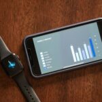 Persona con smartwatch visualizando datos de salud personalizados en pantalla digital, simbolizando la medicina preventiva pe