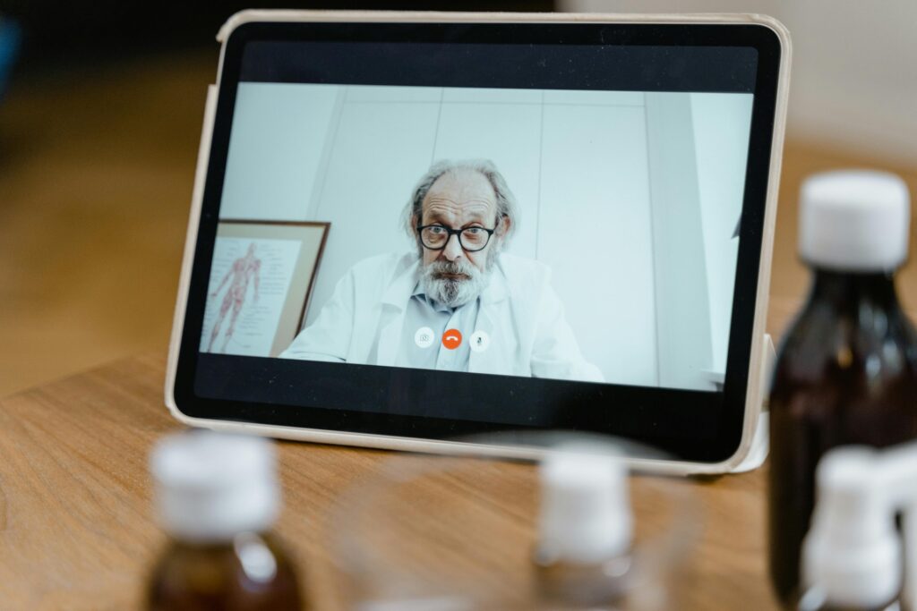 Profesional médico sonriendo durante una consulta de telemedicina segura en una pantalla moderna, mostrando confianza en la p