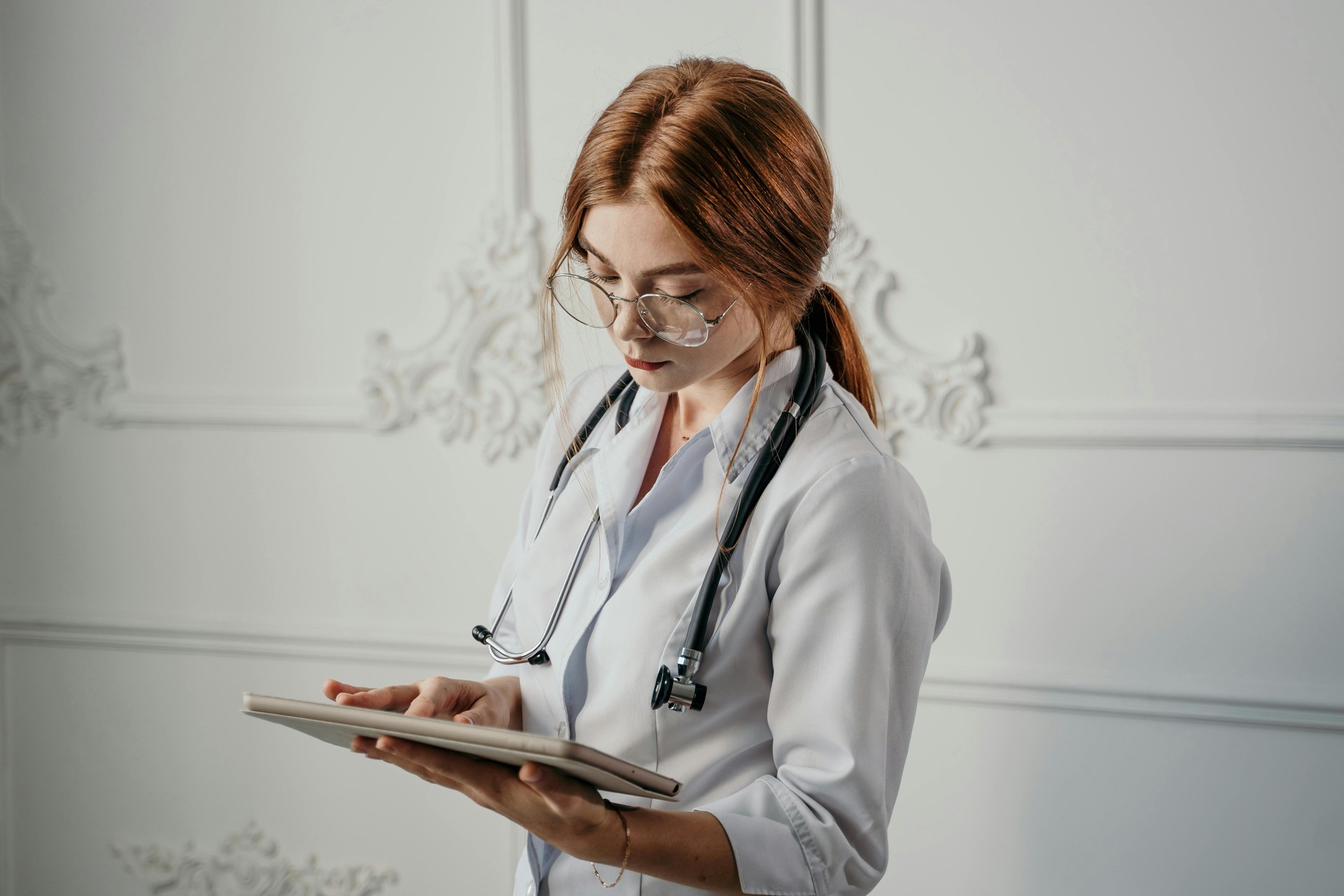 Médico analizando datos de salud en una tablet con interfaz futurista. La IA asiste en diagnósticos y planes de prevención pe