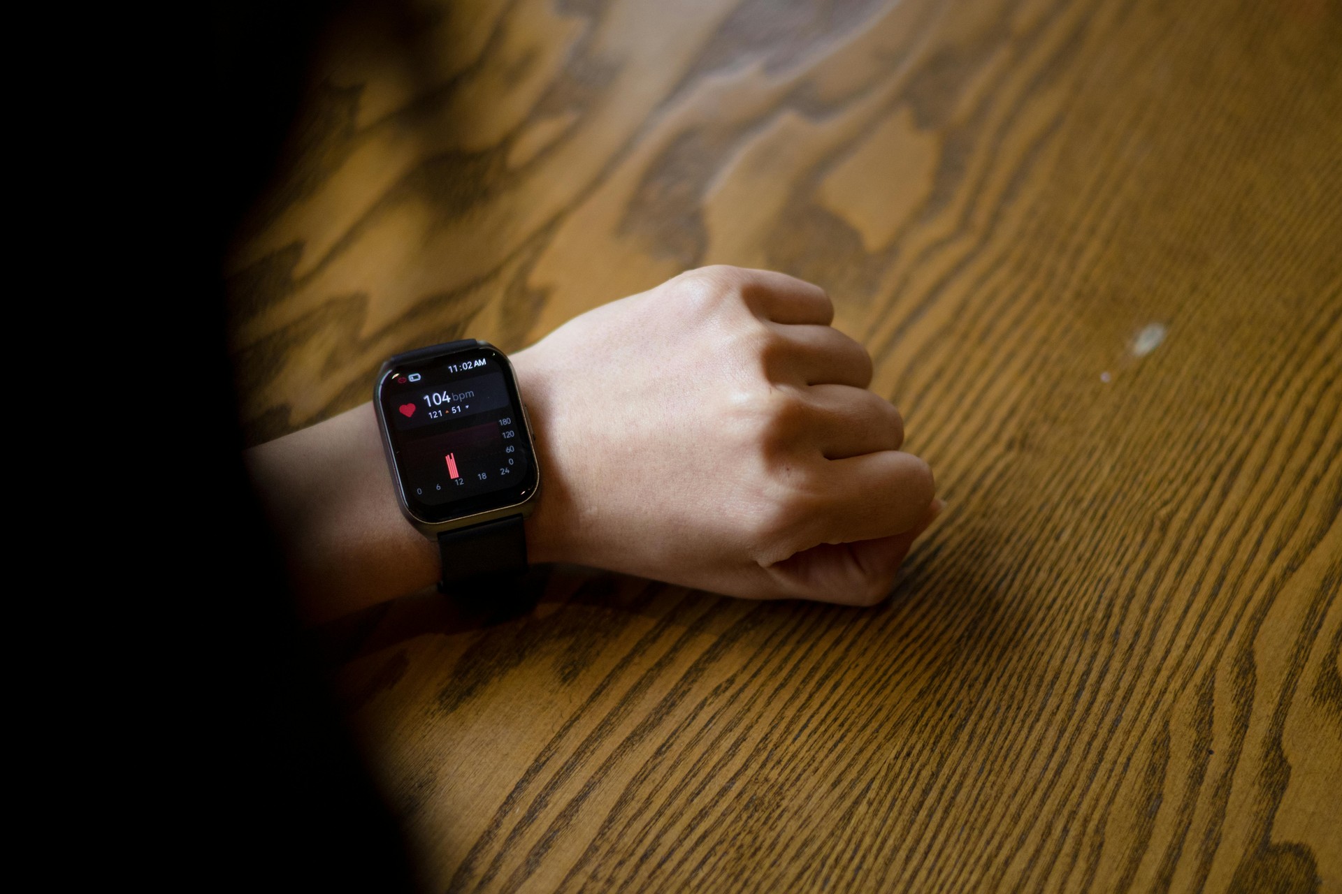 Primer plano de un smartwatch mostrando datos de frecuencia cardíaca, un ejemplo de wearable en salud.