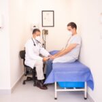 Doctora en clínica moderna muestra en tablet a paciente cómo la Inteligencia Artificial ayuda en la prevención de enfermedade