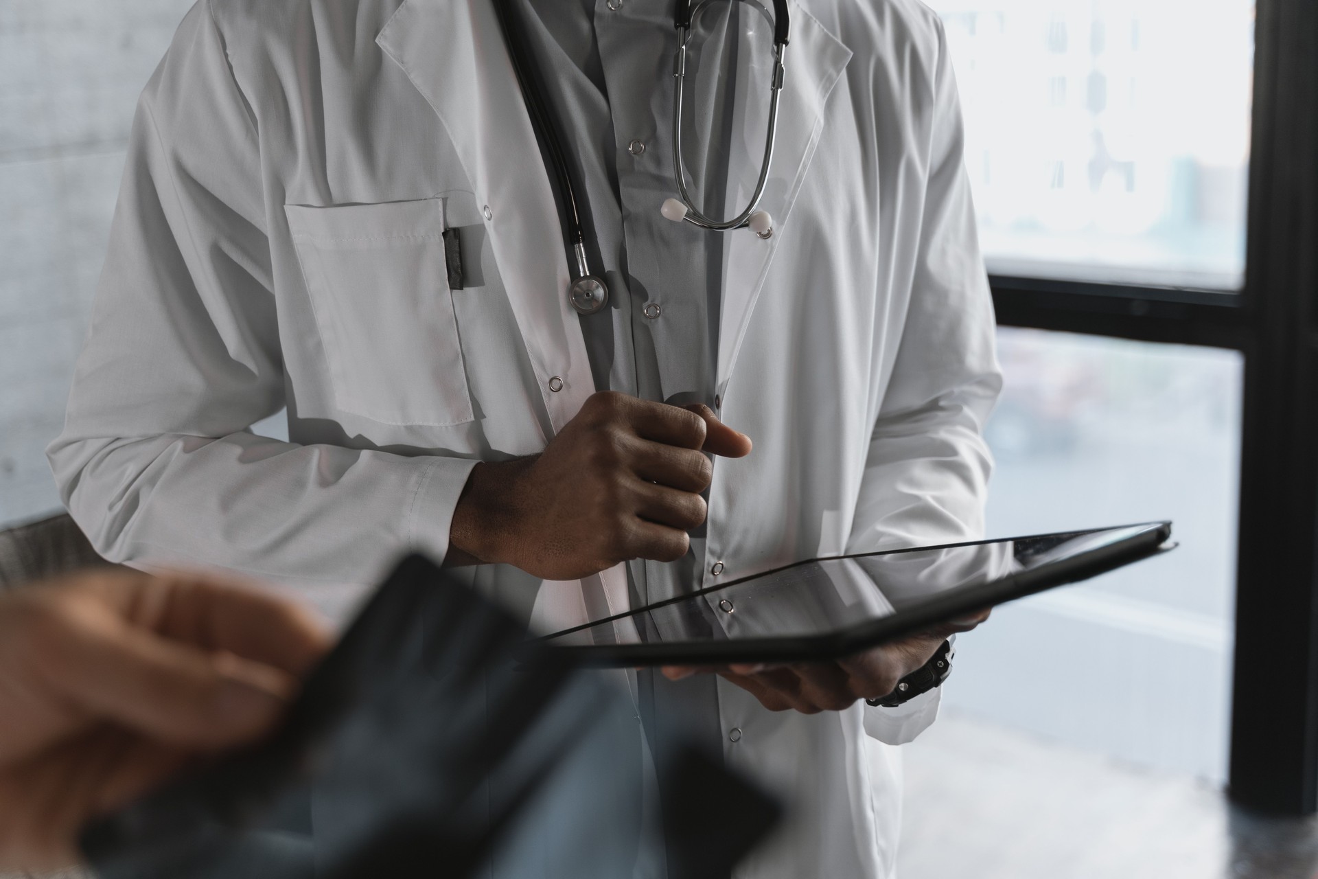 Un médico o especialista usando una tablet con una interfaz de Inteligencia Artificial para analizar imágenes médicas o datos